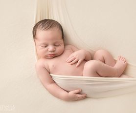 nyfödd bebis i hängmatta på nyföddfotografering