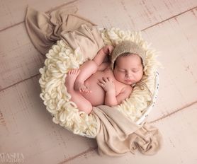 nyfödd bebis sover i en skål på nyföddfotografering