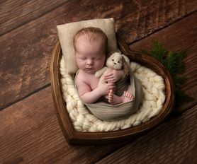 nyföddfotografering nyfödd bebis sover i hjärta formade hink
